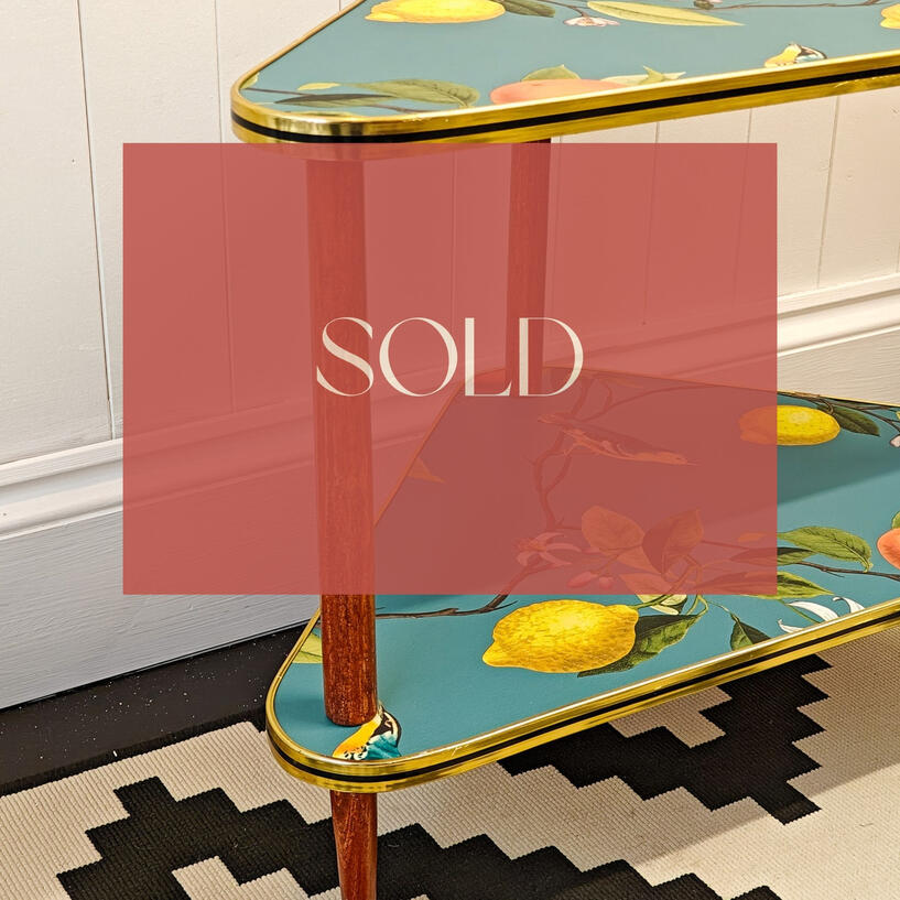 An upcycled mid-century modern corner side table with restored wooden legs, a gorgeous flora and fauna print, retaining the original gold and black trim.